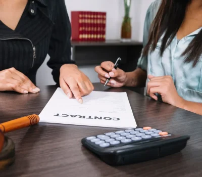 mujer-negra-que-senala-documento-cerca-dama-pluma-mesa-calculadora-martillo_23-2148042590